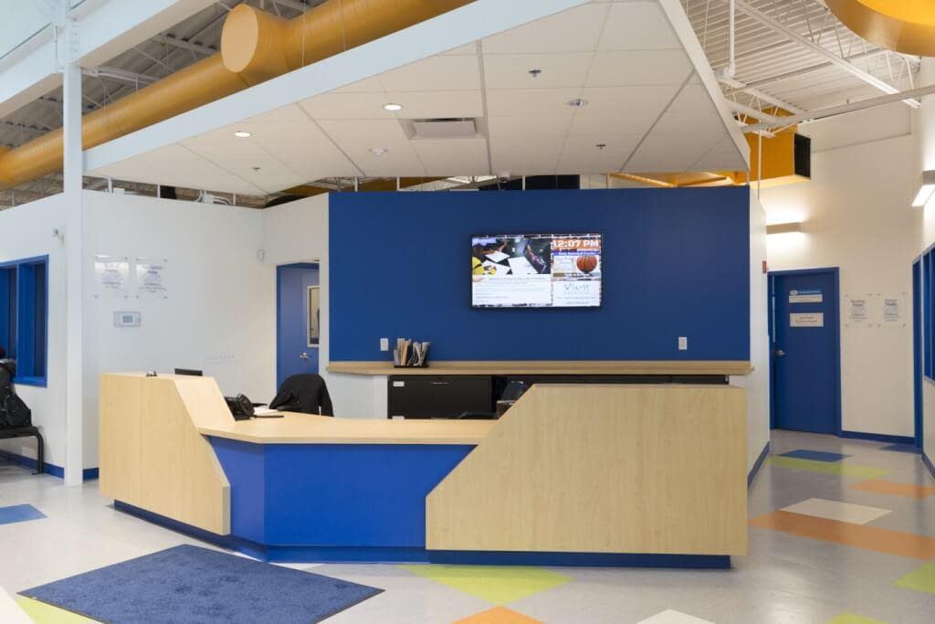 Reception desk Boys and Girls Club Rochester NY floating ceiling exposed structure and exposed ductwork
